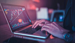 Análise de gráficos em laptop com mão digitando