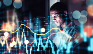 Homem analisando gráficos financeiros digitais.