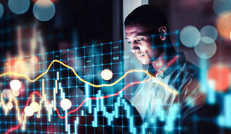 Homem analisando gráficos financeiros digitais.