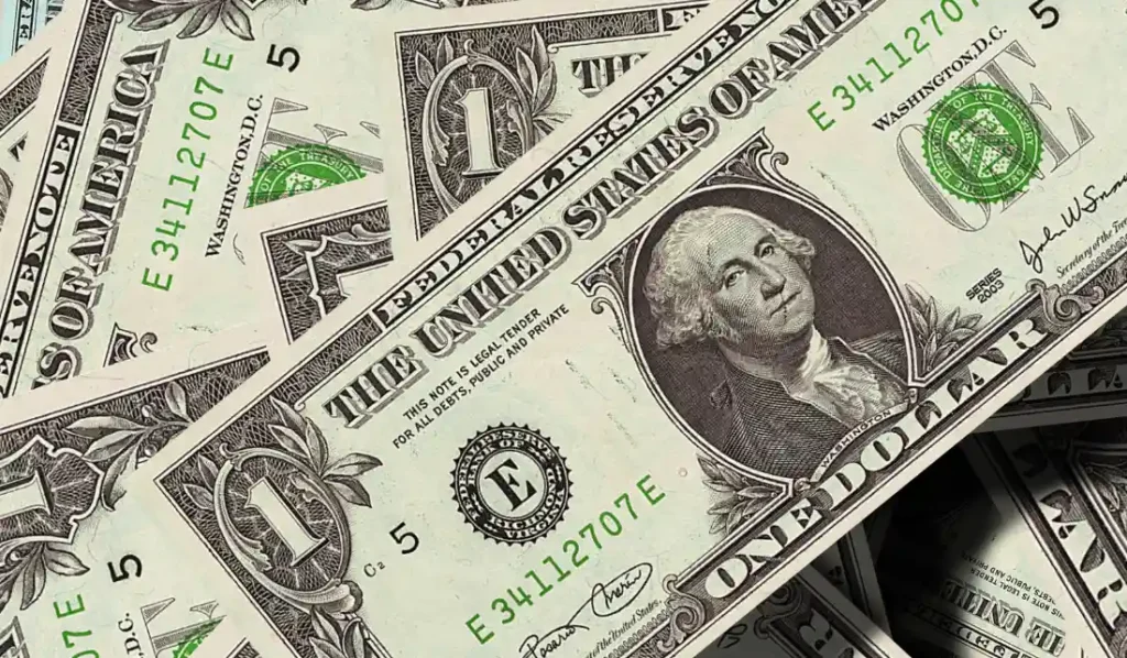 Notas de um dólar dos Estados Unidos em cima de uma mesa.
