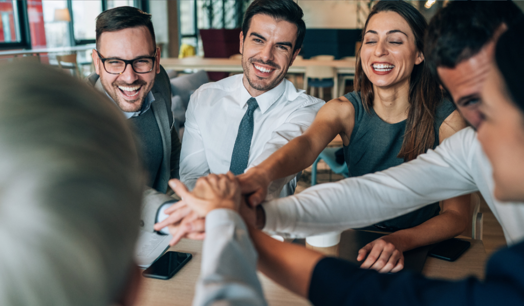 blogeuro43 Equipe sorridente em reunião de negócios celebrando.
