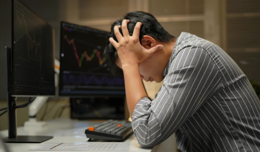 Pessoa estressada analisando gráficos financeiros